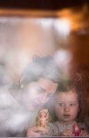 young mother and little cute daughter playing near the window photo