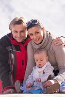 joven familia feliz con un niño pequeño disfrutando del día de invierno foto