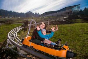 young mother and son driving alpine coaster photo