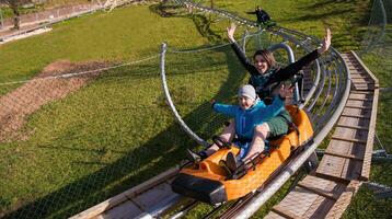 young mother and son driving alpine coaster photo