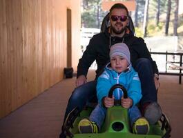 young father and son driving alpine coaster photo