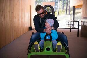 young father and son driving alpine coaster photo