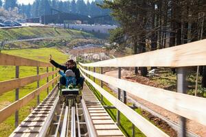 young father and son driving alpine coaster photo