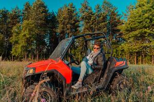 Portrait of young happy excited man enjoying beautiful sunny day while driving a off road buggy car on mountain nature photo