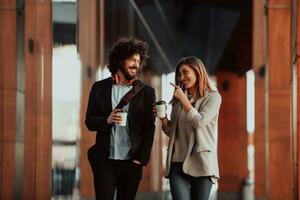 Business man and business woman talking and holding luggage traveling on a business trip, carrying fresh coffee in their hands.Business concept photo