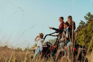 Group young happy people enjoying beautiful sunny day while driving a off road buggy car on mountain nature photo