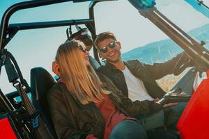 joven contento emocionado Pareja disfrutando hermosa soleado día mientras conducción un apagado la carretera calesa coche en montaña naturaleza foto