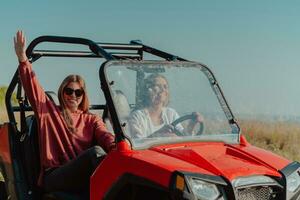 dos joven contento emocionado mujer disfrutando hermosa soleado día mientras conducción un apagado la carretera calesa coche en montaña naturaleza foto