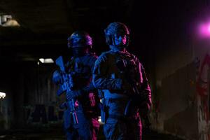 moderno guerra soldados en oscuro con combate munición y armas en el manos de equipado láser monumentos son en batalla orden. mezclado medios de comunicación. foto