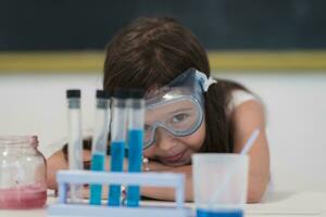 Elementary School Science Classroom Little girl Mixes Chemicals in Beakers. Children Learn with Interest photo