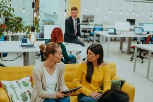 Group of multi-ethnic colleagues working on desktop computers, laptop and sharing their ideas in a modern office space.Young influencers work on online marketing projects. photo