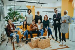 Group of multi-ethnic colleagues working on desktop computers, laptop and sharing their ideas in a modern office space.Young influencers work on online marketing projects. photo