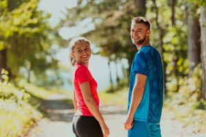 Couple enjoying in a healthy lifestyle while jogging on a country road photo