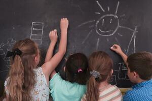 niños escribir y dibujar en el pizarra en elemental colegio mientras aprendizaje el lo esencial de educación foto