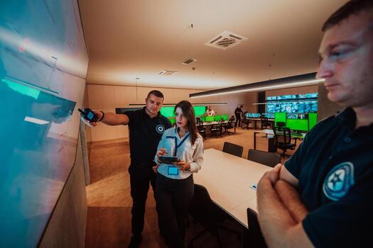 Group of Security data center operators working in a CCTV monitoring room looking on multiple monitors Officers Monitoring Multiple Screens for Suspicious Activities Team working on the System Contr photo
