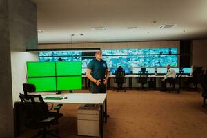 Male security operator working in a data system control room offices Technical Operator Working at workstation with multiple displays, security guard working on multiple monitors Male computer opera photo