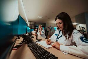 Group of female security operators working in a data system control room Technical Operators Working at workstation with multiple displays, security guards working on multiple monitors in surveillan photo