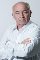 Confident senior man in white shirt crossing hands on chest and looking at camera while standing against gray background. Self confident senior isolated white studio shoot. photo