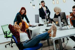 grupo de multiétnico colegas trabajando en escritorio ordenadores, ordenador portátil y compartiendo su ideas en un moderno oficina espacio.joven influencers trabajo en en línea márketing proyectos foto