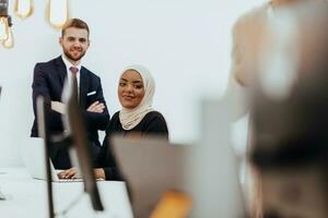 Portrait of a formal businessman and young African American businesswoman posing with their team in a modern startup office. Marketing concept. Multi-ethnic society. photo