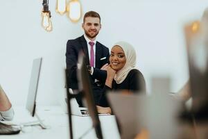 Portrait of a formal businessman and young African American businesswoman posing with their team in a modern startup office. Marketing concept. Multi-ethnic society. photo