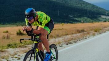 Full length portrait of an active triathlete in sportswear and with a protective helmet riding a bicycle. Selective focus photo