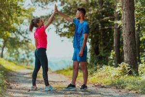 Couple enjoying in a healthy lifestyle while jogging on a country road photo