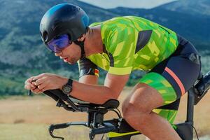 Close up photo of an active triathlete in sportswear and with a protective helmet riding a bicycle. Selective focus