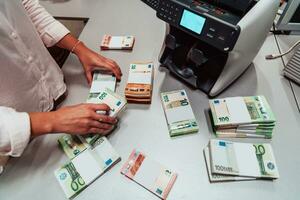 banco empleados utilizando dinero contando máquina mientras clasificación y contando papel billetes dentro banco bóveda. grande cantidades de dinero en el banco foto