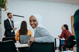 African American Muslim woman listens to a lecture aimed at business training photo