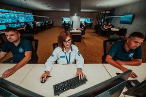 Group of Security data center operators working in a CCTV monitoring room looking on multiple monitors Officers Monitoring Multiple Screens for Suspicious Activities Team working on the System Contr photo