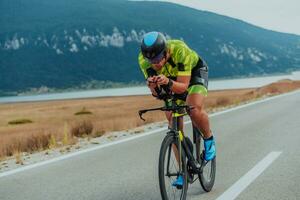 Full length portrait of an active triathlete in sportswear and with a protective helmet riding a bicycle. Selective focus photo