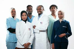 Team or group of a doctor, nurse and medical professional coworkers standing together. Portrait of diverse healthcare workers looking confident. Middle Eastern and African, Muslim medical team. photo