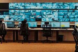 Empty interior of big modern security system control room, workstation with multiple displays, monitoring room with at security data center Empty office, desk, and chairs at a main CCTV security data photo