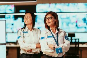 group portrait of female security operator while working in a data system control room offices Technical Operator Working at workstation with multiple displays, security guard working on multiple mon photo