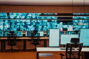 Empty interior of big modern security system control room, workstation with multiple displays, monitoring room with at security data center Empty office, desk, and chairs at a main CCTV security data photo