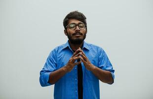 Indian young man Studen showing his concentration and focus with symbolic gestures while standing in front of the school blackboard photo