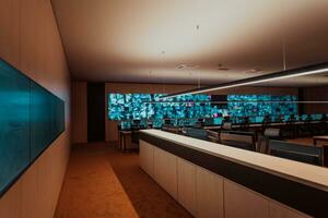 Empty interior of big modern security system control room, workstation with multiple displays, monitoring room with at security data center Empty office, desk, and chairs at a main CCTV security data photo