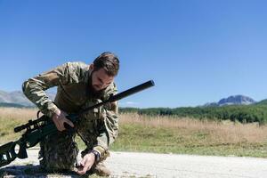 Special operations soldiers team preparing tactical and communication gear for action battle. Long distance sniper team in checking gear for action photo