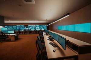 Empty interior of big modern security system control room, workstation with multiple displays, monitoring room with at security data center Empty office, desk, and chairs at a main CCTV security data photo