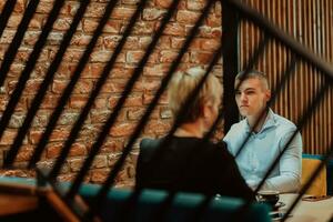 contento gente de negocios sonriente alegremente durante un reunión en un café tienda. grupo de exitoso negocio profesionales trabajando como un equipo en un multicultural lugar de trabajo. foto