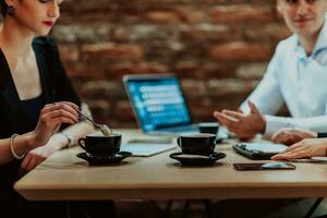 Happy businesspeople smiling cheerfully during a meeting in a coffee shop. Group of successful business professionals working as a team in a multicultural workplace. photo