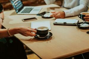 contento gente de negocios sonriente alegremente durante un reunión en un café tienda. grupo de exitoso negocio profesionales trabajando como un equipo en un multicultural lugar de trabajo. foto