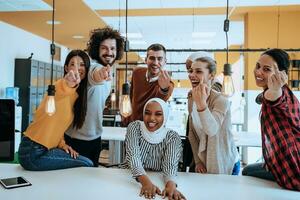 Group of diverse young man and girl in modern office showing middle finger photo