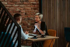 Happy businesspeople smiling cheerfully during a meeting in a coffee shop. Group of successful business professionals working as a team in a multicultural workplace. photo