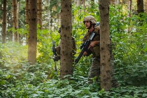 A group of modern warfare soldiers is fighting a war in dangerous remote forest areas. A group of soldiers is fighting on the enemy line with modern weapons. The concept of warfare and military conflicts photo