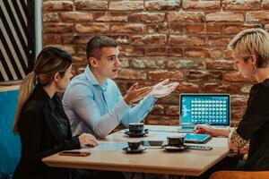 Happy businesspeople smiling cheerfully during a meeting in a coffee shop. Group of successful business professionals working as a team in a multicultural workplace. photo