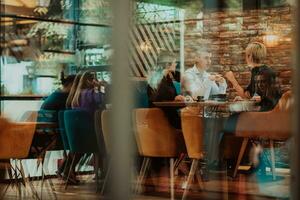 Happy businesspeople smiling cheerfully during a meeting in a coffee shop. Group of successful business professionals working as a team in a multicultural workplace. photo