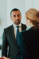 Photo of a businessman and businesswoman discussing business projects in a modern corporation. Selective focus