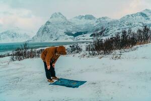 A Muslim traveling through arctic cold regions while performing the Muslim prayer namaz during breaks photo